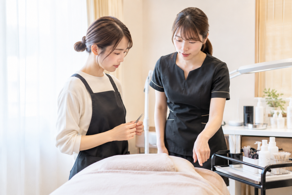 サロンで施術台の前に立ち、スタッフが確認しながら説明している様子