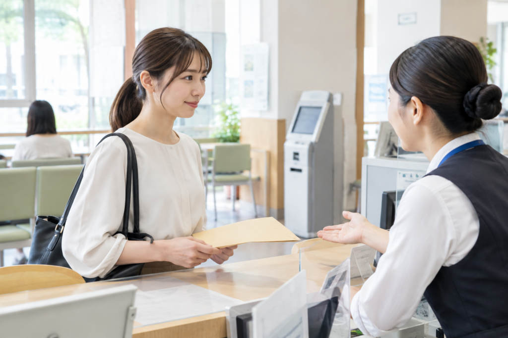 サロンの受付で、女性がスタッフから書類を受け取っている