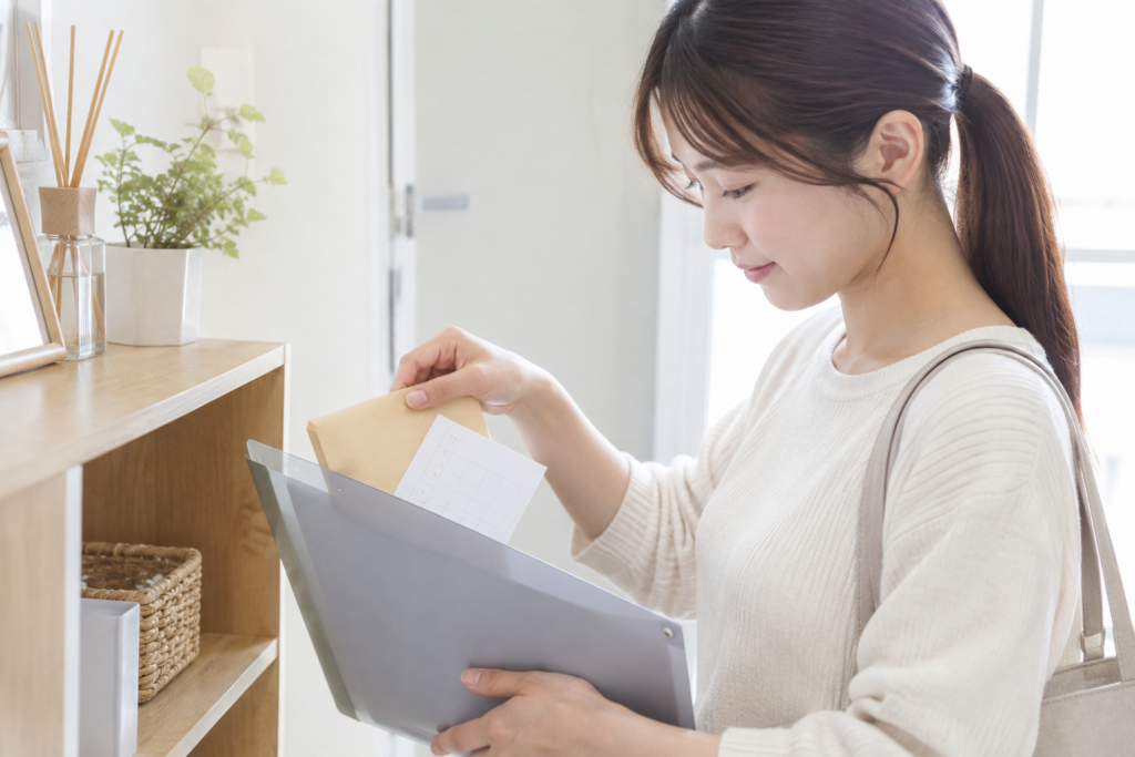 女性が室内で封筒と書類を確認している