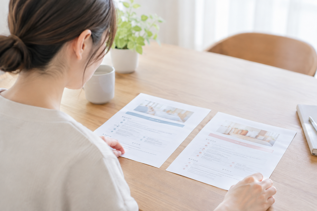 机の上の求人資料を見比べる女性